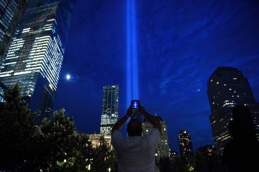 A man photographs beams of light symbolizing the two World Trade Center towers the night before the 15th anniversary of the September 11, 2001 terrorist attacks in the United States on September 10, 2016 in New York, New York. / AFP / Brendan Smialowski (Photo credit should read BRENDAN SMIALOWSKI/AFP via Getty Images)